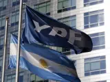 Una bandera argentina junto a una bandera de YPF en la sede de la empresa petrolera en Buenos Aires.