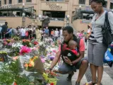 Una familia deja flores en la Nelson Mandela Square, en Johannesburgo.