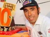 El piloto Nani Roma posa con una tarta en la que se recuerdan los diez años de su triunfo en la categoría de motos.