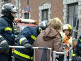 Bomberos del Ayuntamiento de Madrid rescatan a cinco vecinos por la fachada con una autoescala tras un incendio en el edificio que ha provocado varios intoxicados por humo.