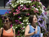 Dos mujeres pasan, en una calle del centro de Ourense, ante un termómetro que marca 44 grados.