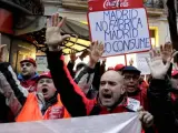 Trabajadores de Coca Cola durante la concentración que han llevado a cabo ante la sede del PP de Madrid para exigir a la empresa que dé marcha atrás en sus planes para cerrar su planta de Fuenlabrada.