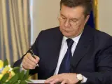 El presidente de Ucrania, Viktor Yanukovich, durante la firma del acuerdo con los tres líderes de la oposición parlamentaria, después de tres meses de protestas antigubernamentales en las que murieron decenas de personas.