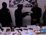 Imagen del vídeo que ha publicado la BBC en el que se ve cómo dos encapuchados de ETA entregan parte de sus armas a los verifcadores internacionales.