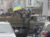 Un grupo de manifestantes opositores a Yanukovich ondea una bandera de Ucrania desde un vehículo militar en pleno centro de Kiev, la capital del país.