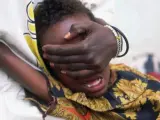 Una niña de seis años grita de dolor mientras le practican una mutilación genital en Somalia. Su hermana de 18 años la sostiene.