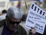 Un manifestante porta una pancarta contra la estafa de las participaciones preferentes en el marco de la 'marea ciudadana'.