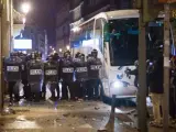 Agentes antidisturbios se protegen con escudos para enfrentarse a manifestantes violentos en el centro de Madrid.