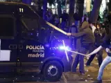 Manifestantes atacan con palos un vehículo de la Policía Municipal de Madrid.