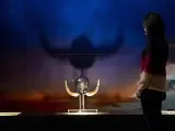 Una mujer observa una réplica de un casco vikingo en la exposición sobre este pueblo nórdico inaugurada en Barcelona.