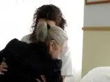 Una axuliar ayuda a una anciana.