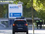 Un coche de la Policía Nacional y tres agentes de la Policía Local de Madrid patrullan en los alrededores del Madrid Arena.