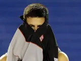 El serbio Novak Djokovic se cambia de camiseta durante su partido de cuartos de final del Abierto de Australia disputado ante el suizo Stanislas Wawrinka.