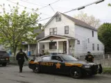 Varios agentes frente a la casa donde permanecieron secuestradas durante diez años.