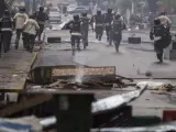 Miembros de la Policía Nacional Bolivariana intentan dispersar en Caracas a un grupo de manifestantes opositores al Gobierno.