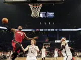 LeBron James (i) de Heat ante Andrei Kirilenko (c) de Nets, durante el cuarto partido de las semifinales de la Conferencia Este de la NBA.