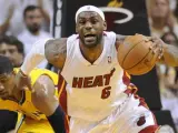 LeBron James, de los Miami Heat, controla una bola con la oposición de Paul George, de los Indiana Pacers.