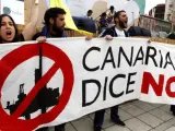 Varias personas protestan con pancartas contra las prospecciones petrolíferas autorizadas por el Ministerio de Medio Ambiente en aguas de Canarias durante los actos organizados con motivo de la celebración del Día de Canarias.