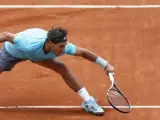 El tenista español Rafael Nadal, número uno en el ránking mundial, se estira para golpear la bola durante su partido de la segunda ronda del Roland Garros disputado contra el austríaco Dominic Thiem en París (Francia).
