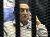 El expresidente egipcio Hosni Mubarak permanece sentado tras los barrotes durante una sesión celebrada en un tribunal en El Cairo.