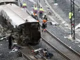 Los servicios de emergencia trabajan junto a las vías tras el accidente del tren Alvia que cubría la ruta entre Madrid y Ferrol y que descarriló cuando ya estaba muy cerca de Santiago de Compostela.