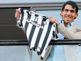 El futbolista argentino Carlos Tévez muestra la camiseta de su nuevo equipo, la Juventus de Turín, donde lucirá el dorsal número 10. La 'vecchia signora' ha pagado 12 millones de euros al conjunto inglés del Manchester City.