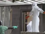 Imagen que muestra a enfermeras de Liberia protegidos con ropas especiales y desinfectándose después de tratar a varias víctimas afectadas con ébola en un hospital de Monrovia, Liberia.