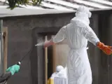 Una enfermera siendo desinfectada en Liberia, tras preparar varios cadáveres del virus del Ébola para ser enterrados.