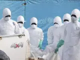 Una imagen muestra a agentes de salud de Liberia de camino a enterrar a una mujer que murió por el virus del ébola este domingo.