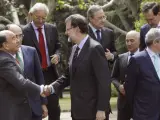 El presidente del Gobierno, Mariano Rajoy (c), saluda al presidente del Banco Santander, Emilio Botín (i), durante el posado para la fotografía de familia con los grandes empresarios españoles que integran el Consejo Empresarial por la Competitividad.