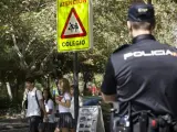 Agentes de la Policía Nacional vigilan la salida de un colegio en el distrito madrileño de Ciudad Lineal.