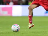 Dos jugadores pugnan por la posesión de un balón de fútbol durante un partido.