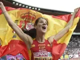 La saltadora cántabra Ruth Beitia celebra con la bandera de España su victoria en la prueba de salto de altura.