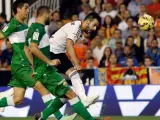 El delantero del Valencia Álvaro Negredo (d) dispara a puerta durante el encuentro correspondiente a la novena jornada de primera división, que su equipo disputa ante el Elche en el estadio de Mestalla.