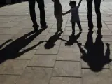 Una familia caminando de espaldas.