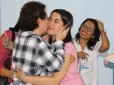 Efusivo beso de Teresa Romero (de espalda, con camisa a cuadros) a una de las personas que le han recibido tras salir del aislamiento en el Carlos III.