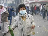 Un menor sostiene un cóctel molotov durante unos disturbios con la policía en Egipto.
