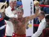 El actor y boxeador estadounidense Mickey Rourke (izda) saluda tras el combate con su compatriota Elliot Seymour (dcha) disputado en Moscú, Rusia.