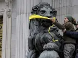 Fotograf&iacute;a facilitada por Greenpeace de sus activistas, amordazando uno de los leones que presiden la fachada del Congreso de los Diputados en Madrid, como acto de protesta pac&iacute;fica contra el anteproyecto de Ley de Protecci&oacute;n de la Seguridad Ciudadana (conocida popularmente como 'ley mordaza').