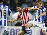 El delantero islandés de la Real Sociedad Alfred Finnbogason (d) pelea un balón con el centrocampista del Athletic Club de Bilbao Oscar de Marcos.