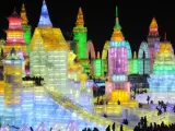 Un grupo de visitantes pasea entre las esculturas iluminadas de la Ciudad de hielo, en la ciudad china de Harbin. El festival de esculturas de hielo y nieve de Harbin re&uacute;ne cada a&ntilde;o a miles de visitantes que contemplan asombrados su m&aacute;s de 750.000 metros cuadrados dedicados al arte en hielo y nieve.