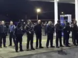 Captura de video que muestra a la policía formando un cordón de seguridad en la gasolinera donde un policía ha disparado y matado a un joven negro que iba armado en Berkeley, Misuri.