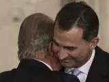 El rey Juan Carlos abraza al príncipe de Asturias, Felipe de Borbón, tras sancionar la ley orgánica que hace efectiva su abdicación.