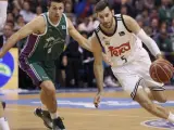El alero del Real Madrid, Rudy Fernández (d), supera la defensa del escolta norteamericano del Unicaja, Ryan Toolson (i), durante el partido correspondiente a la decimocuarta jornada de la ACB.