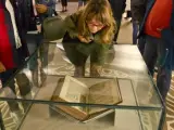 Varias personas contemplan el Códice Calixtino, ubicado en una urna de cristal blindado.