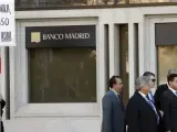 Un hombre protesta ante la sede del Banco de Madrid, intervenido este martes por el Banco de España.