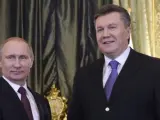 El presidente ruso, Vladimir Putin (i), estrecha la mano al expresidente ucraniano, Viktor Yanukovich, en el Gran Palacio del Kremlin de Moscú.