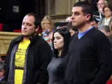 Los diputados de la CUP David Fernández, Isabel Vallet y Quim Arrufat escuchan, de pie, la respuesta del consejero de Interior, Ramon Espadaler, antes de abandonar el hemiciclo en protesta por la condena de ocho indignados por el asedio al Parlament.
