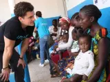 El actor británico y embajador de buena voluntad de Unicef Orlando Bloom (i) habla con una mujer durante una visita a la clínica Pipeline en Montserrado (Liberia).