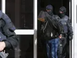 Agentes de los Mossos d'Esquadra custodian a una de los detenidos en el marco de una operación contra el terrorismo yihadista en Cataluña.